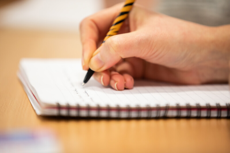 person writing in a notebook